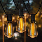 String of illuminated light bulbs against a blurred outdoor background